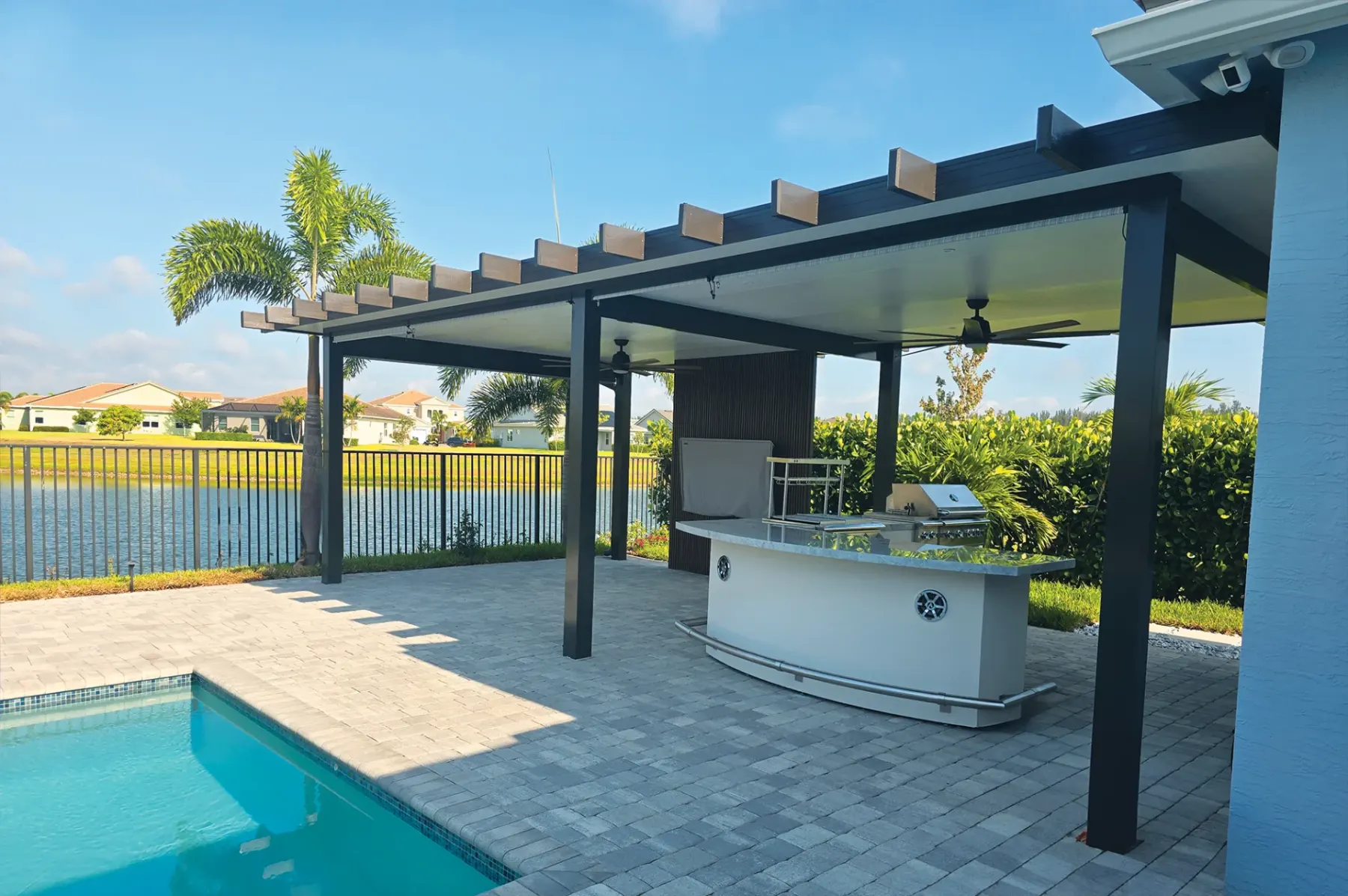 Naturewood aluminum pergola beside a sunlit pool and lake