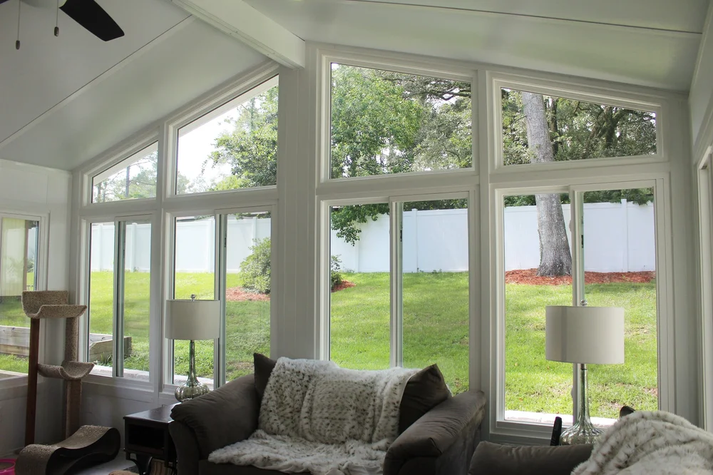 Sunroom interior shaped by broad glazed openings